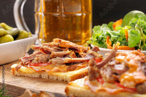 Sandwich with shredded pork roasted potatoes and salad