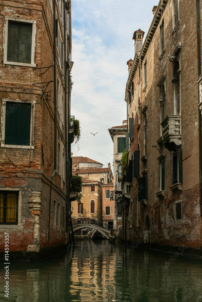 Venetian narrow canal among classical shabby houses