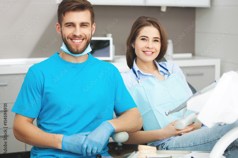 Portrait of a male dentist and young happy female patient. Portrait of a male dentist and young happy female patient.