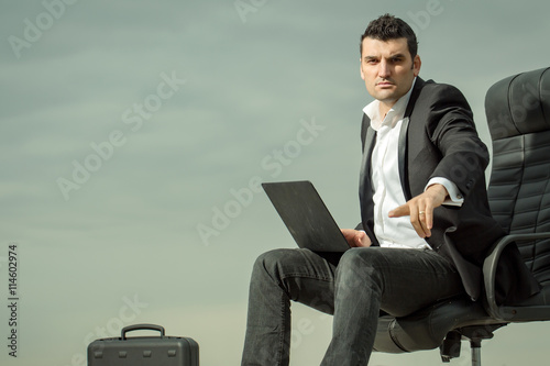 businessman with laptop on chair outdoor