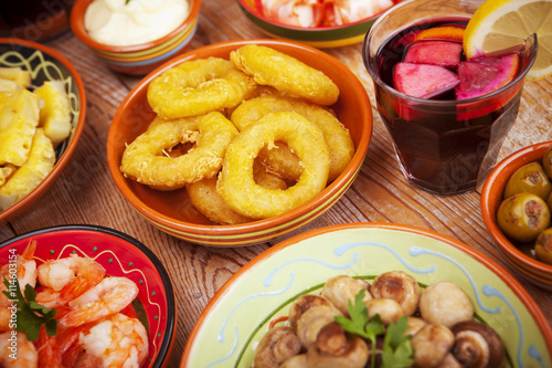 Assortment of Spanish tapas and sangria on a rustic table