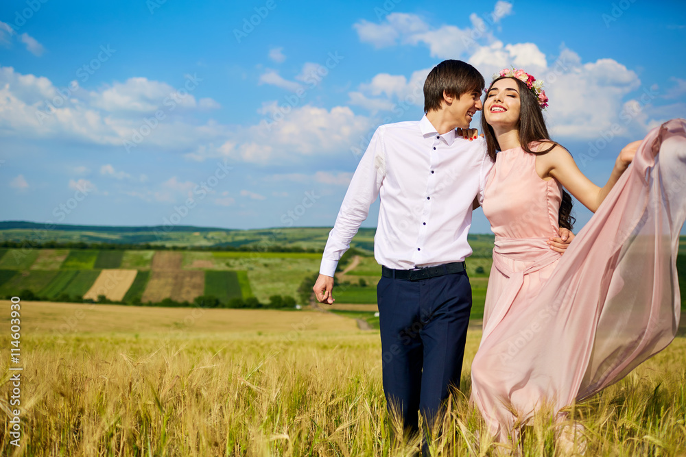 Loving couple embracing on the go zhelotomu field summer day, laughing. Concept of love, happiness and freedom. Love beautiful couple on nature. Loving couple embracing on the go zhelotomu field summer day, laughing. Concept of love, happiness and freedom. Love beautiful couple on nature.