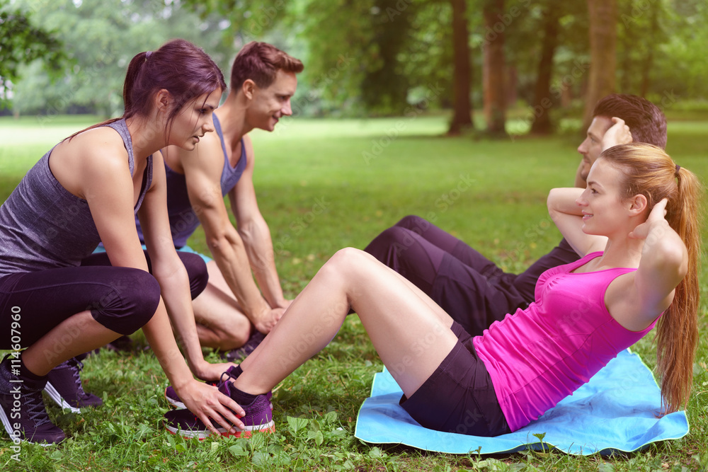 gruppe trainiert sit-ups im park gruppe trainiert sit-ups im park