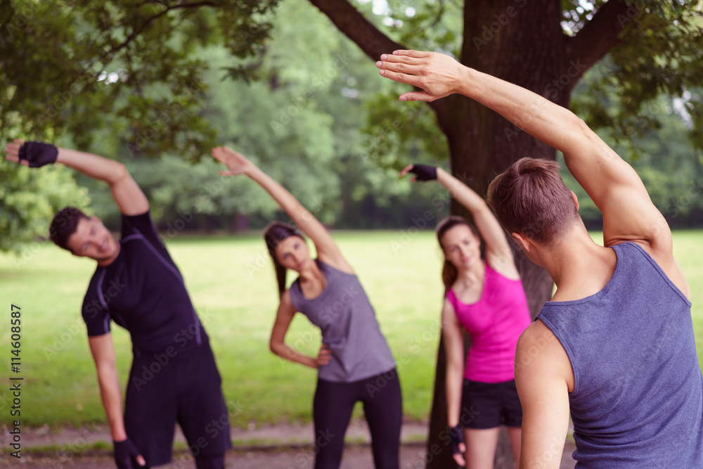 Fototapeta premium gruppe trainiert mit einem trainer draußen im park