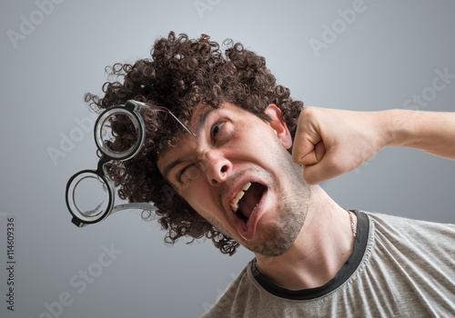 Funny man is getting punch in face with fist. photo