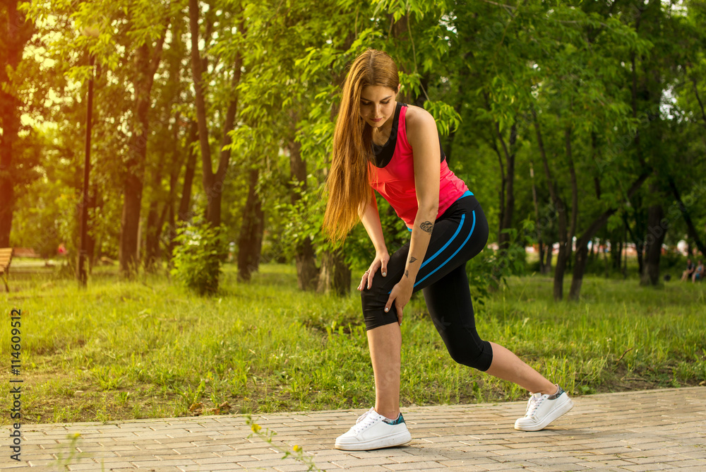 Woman in pain while running in park Woman in pain while running in park