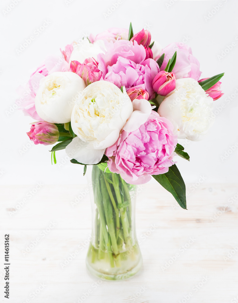 Summer bouquet of peonies on a white wooden table