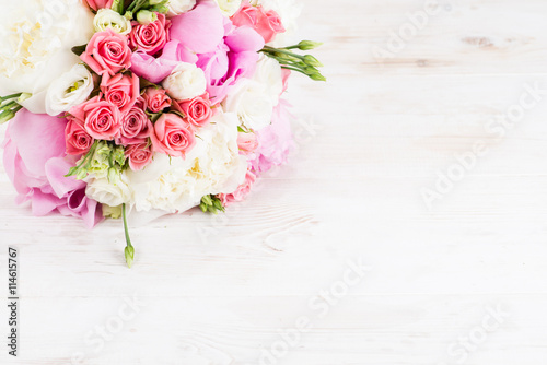 Summer bouquet of pions on the white wooden background and space