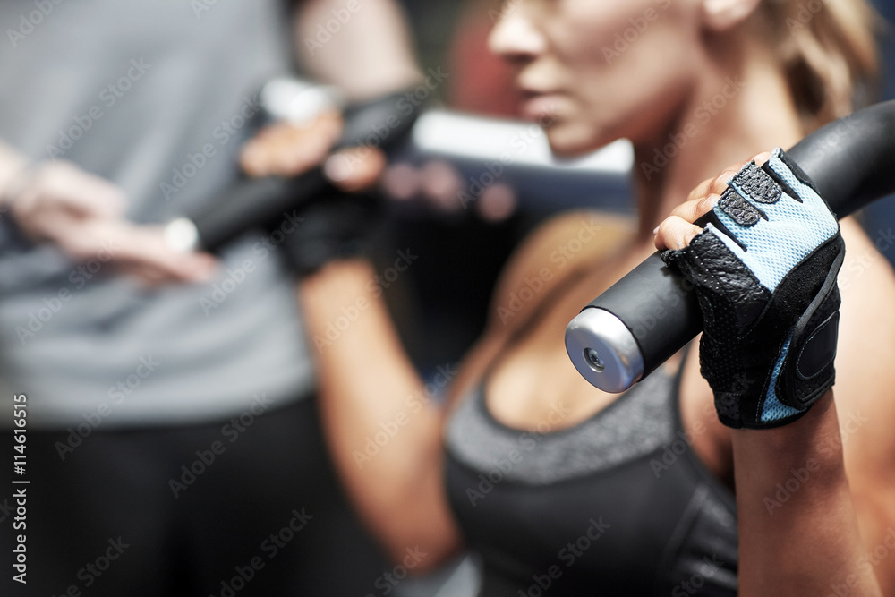 man and woman flexing muscles on gym machine man and woman flexing muscles on gym machine