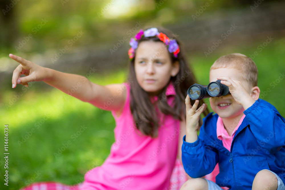 Obraz premium Boy and girl exploring the environment with a binocular
