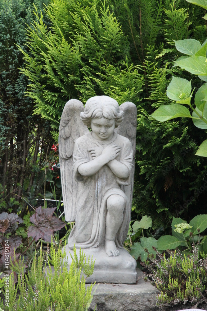 Engel auf dem Friedhof verschränkt die Arme vor der Brust