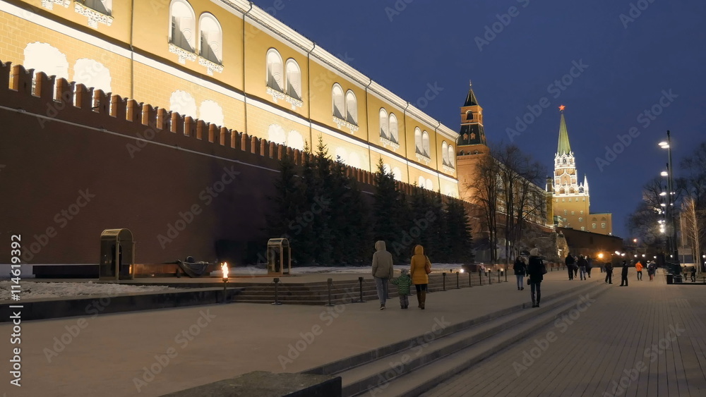 family is going to eternal flame near a wall of Moscow Kremlin in evening