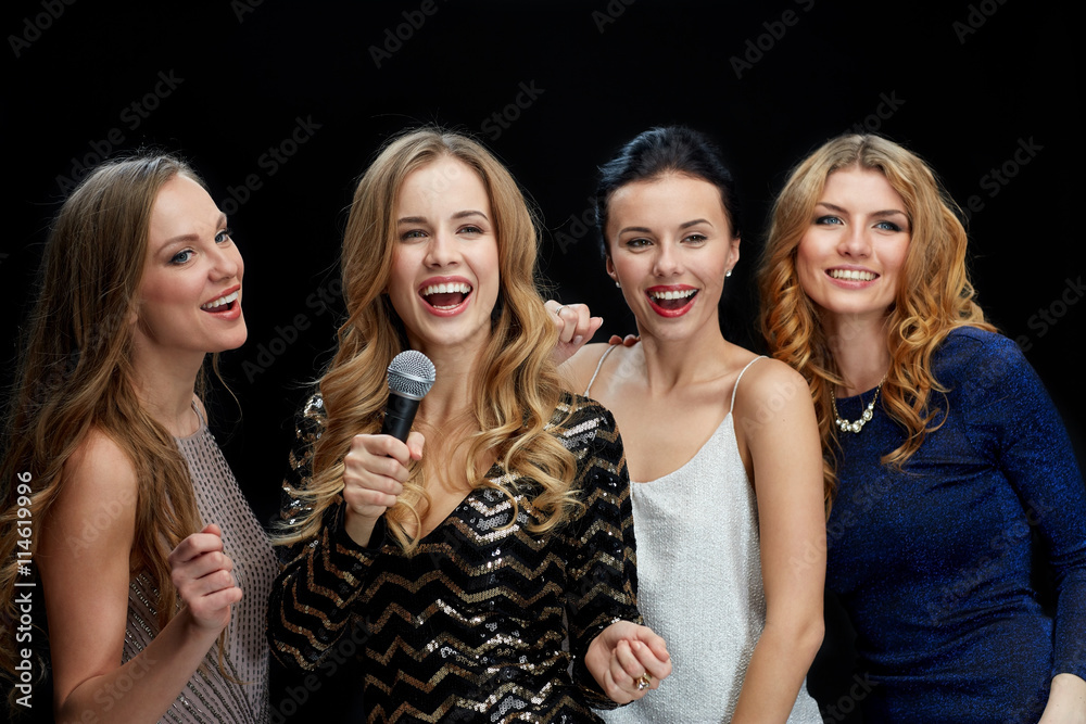 happy young women with microphone singing karaoke happy young women with microphone singing karaoke