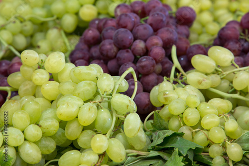 red and green grapes in a market stand