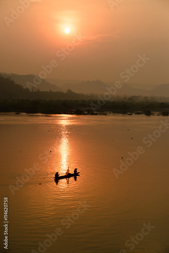 fisherman on boat with sunrise background, the Mekong River in Thailand © prachid