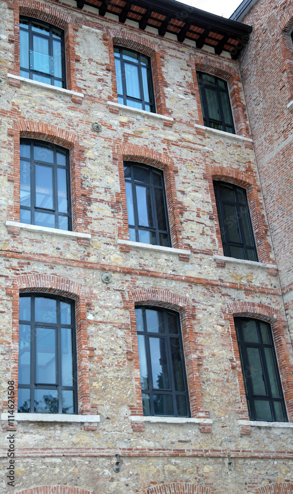 architectural detail of the large windows of an old industrial b
