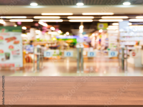 Wooden empty table in front of blurred supermarket