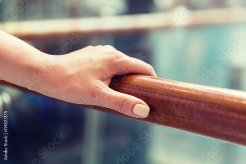 close up of woman hand holding to railing