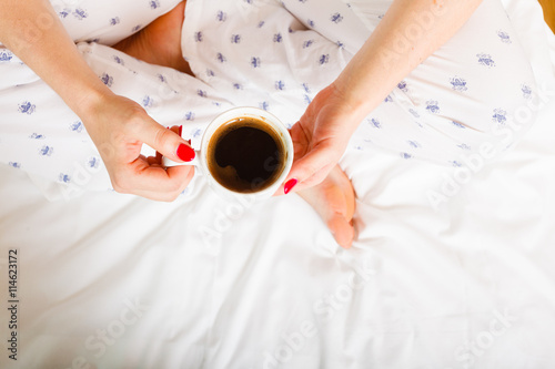 woman on bed with cup of coffee