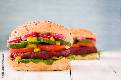 Veggie beet burger on white wooden and blue background