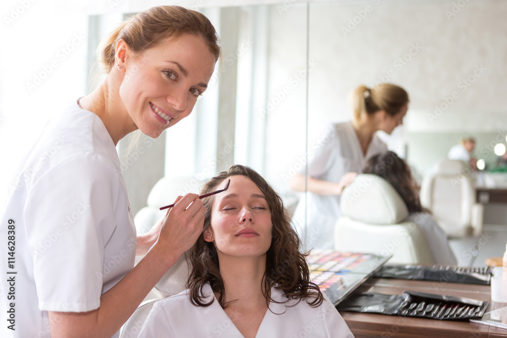Obraz premium Two young beautician students working during make up classes