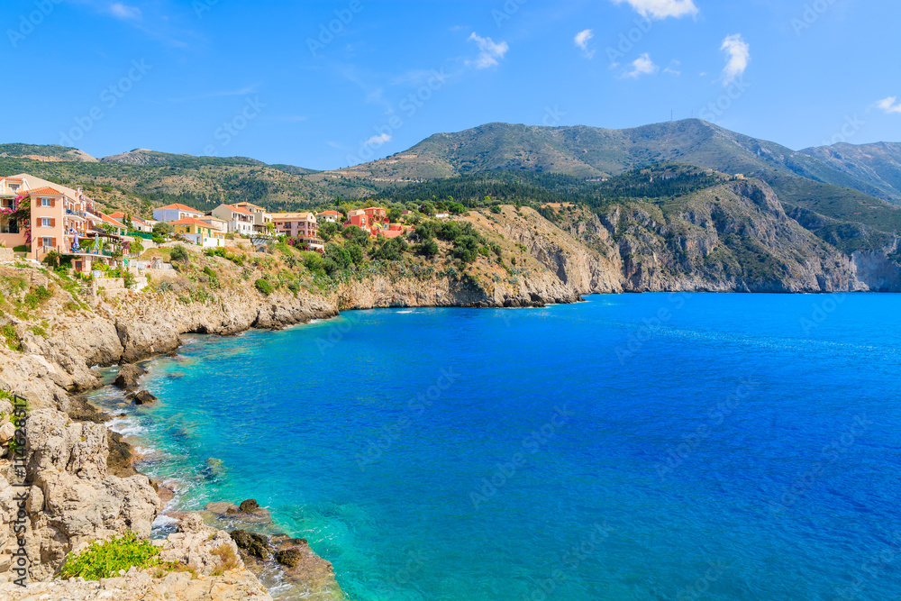 Sea bay with colorful houses built on hill near Assos village on Kefalonia island, Greece