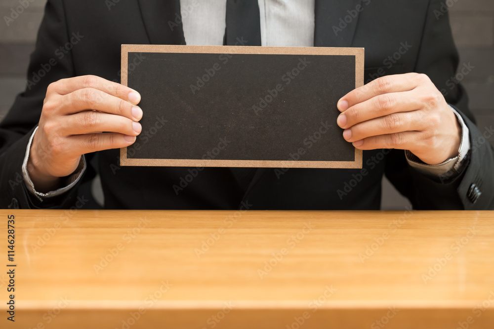 Hand of businessman showing black board Hand of businessman showing black board
