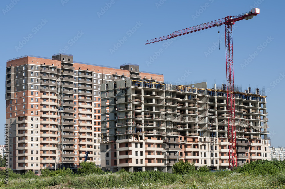 Two houses under construction and crane nearby. Two houses under construction and crane nearby.
