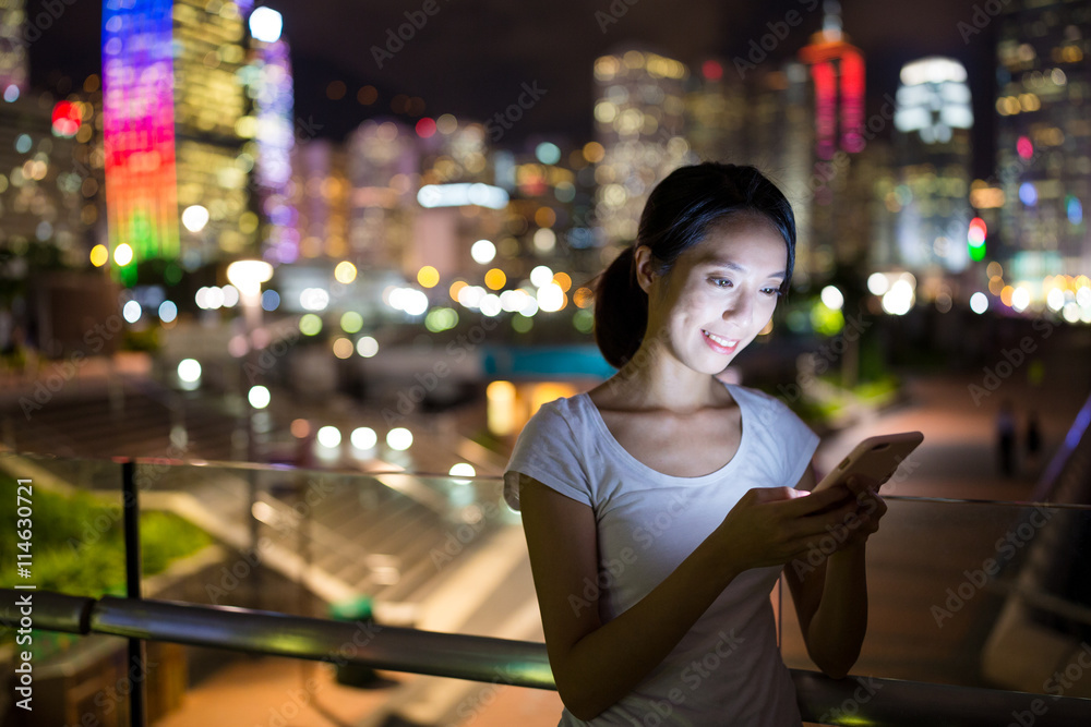 Woman looking at mobile phone at night