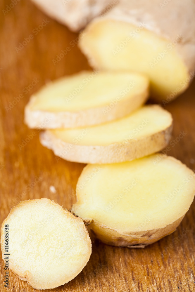 Close up of different forms of ginger against a wood worktop. Selective focus.