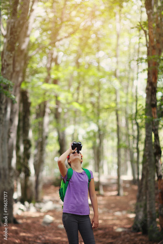 Girl watching with binocular in the forest