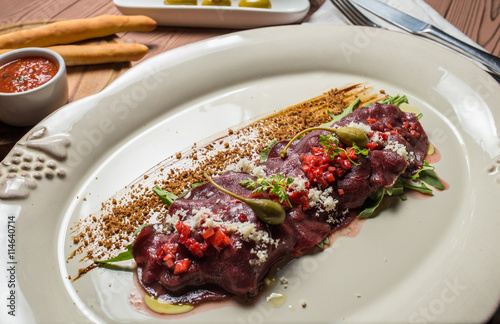 carpaccio with deer served on white plate