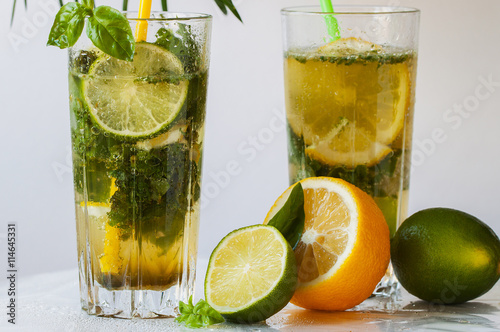 Refreshing summer cocktail with green basil, citruses and ice