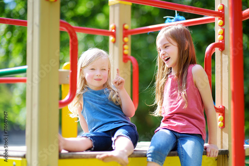 Two cute little girls having fun on a playground
