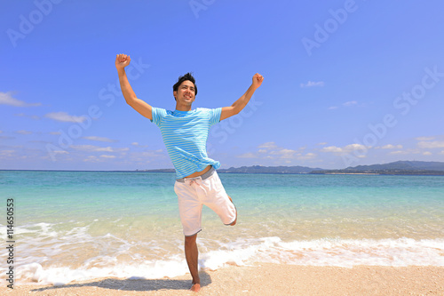 沖縄の美しいビーチで寛ぐ男性  © sunabesyou