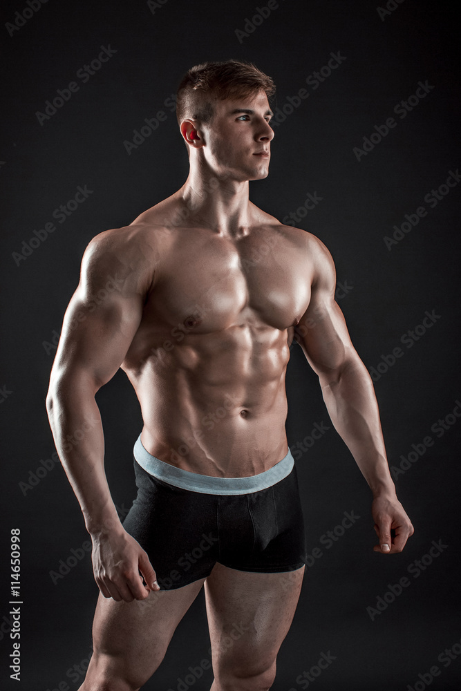 Muscular bodybuilder guy doing posing over black background Muscular bodybuilder guy doing posing over black background