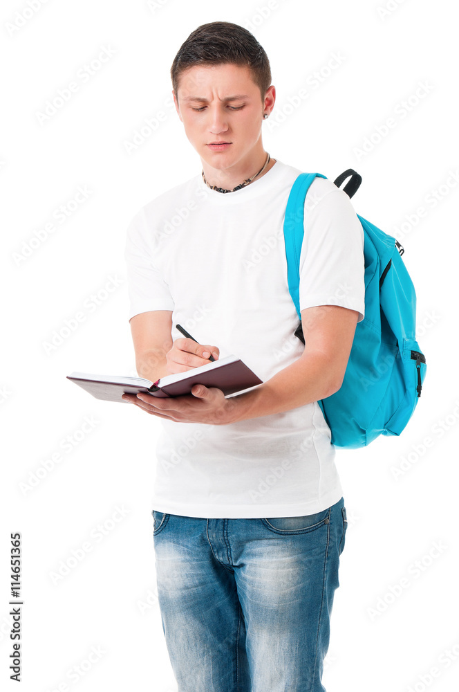 Portrait of a caucasian guy carrying some books and a backpack, isolated on white background. Smart  student of college or university writes in a notebook lecture.