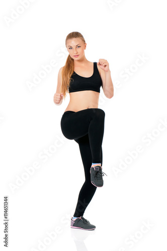 Fitness woman doing stretching exercise, full length portrait isolated over white background