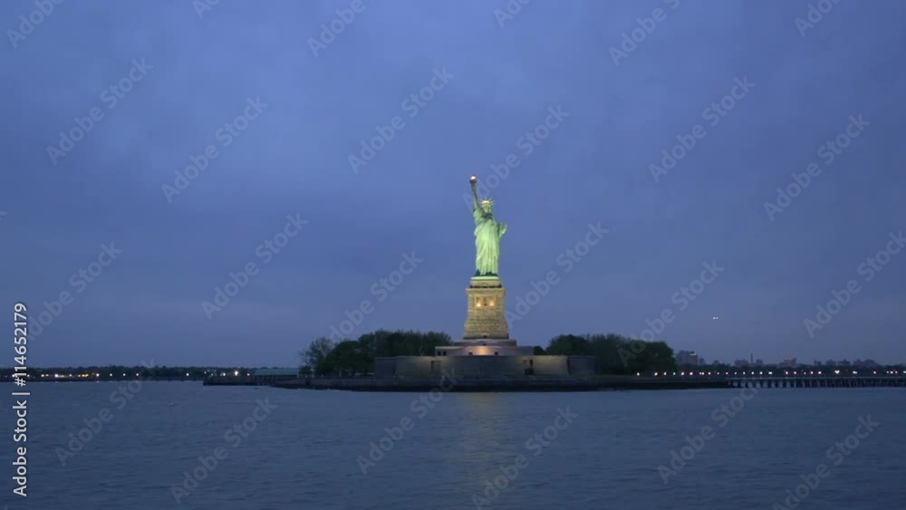 Statue of Liberty at night with a cruise passing by, New York City, USA Statue of Liberty at night with a cruise passing by, New York City, USA