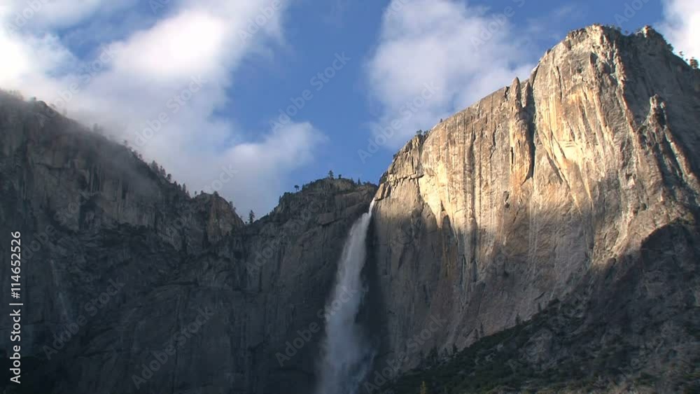 Waterfall out mountain wall in the shadow