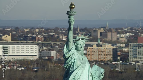 Close orbit of the upper portion of the Statue of Liberty, Jersey City in background. Shot in 2011.