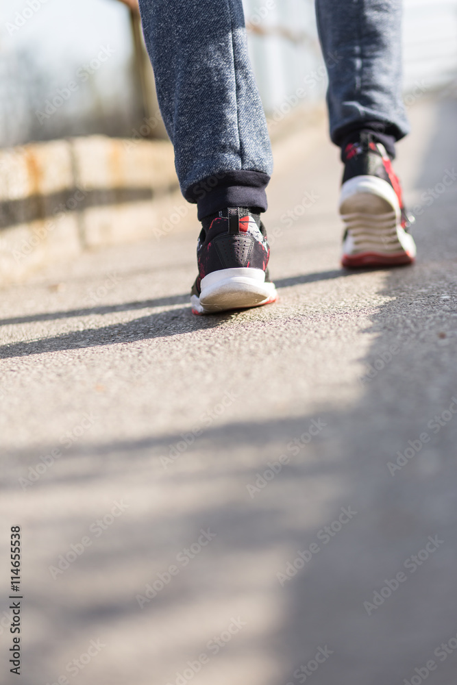 Running sport. Man runner legs and shoes in action on road outdo Running sport. Man runner legs and shoes in action on road outdo