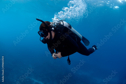 Scuba diver exploring deep reef.