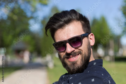 Young man relaxing on park bench on a summers day