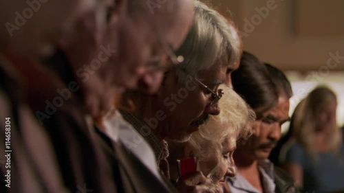 Seated congregation praying with bowed heads