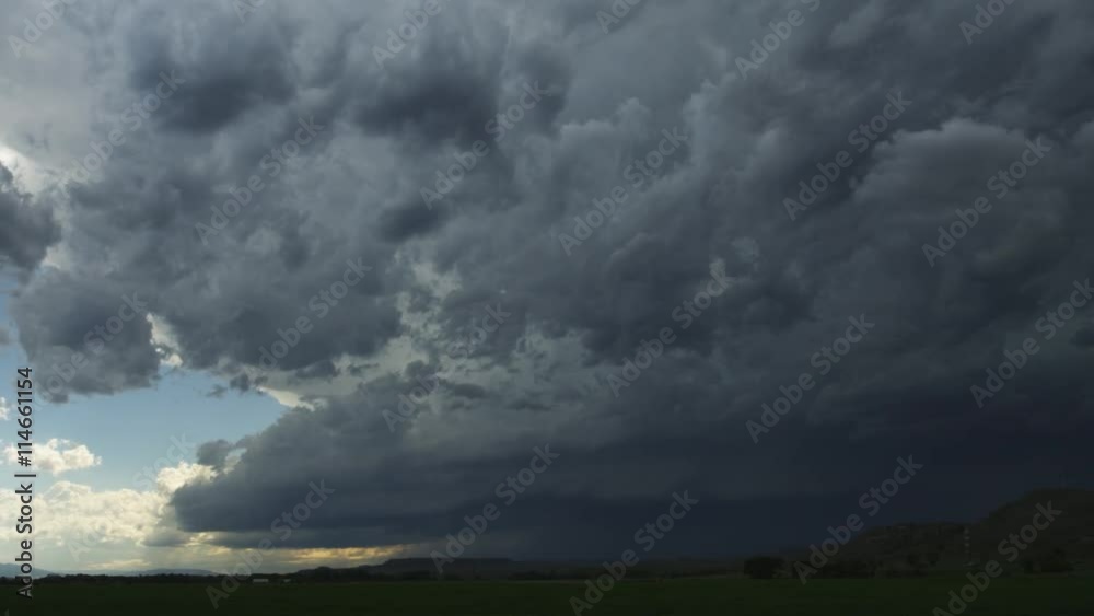 Fast-moving gray clouds sweep over prairie and hills Fast-moving gray clouds sweep over prairie and hills