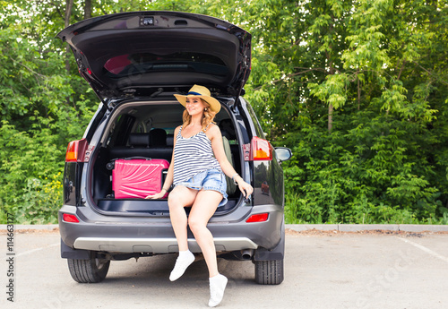 Young woman and suitcase. Vacation concept. Car trip. Summer travel. Girl traveling with suitcases