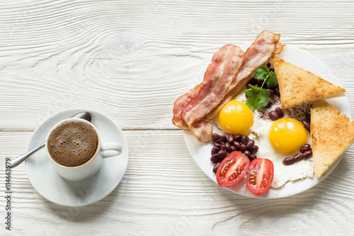 English breakfast with bacon, fried egg, baked beans