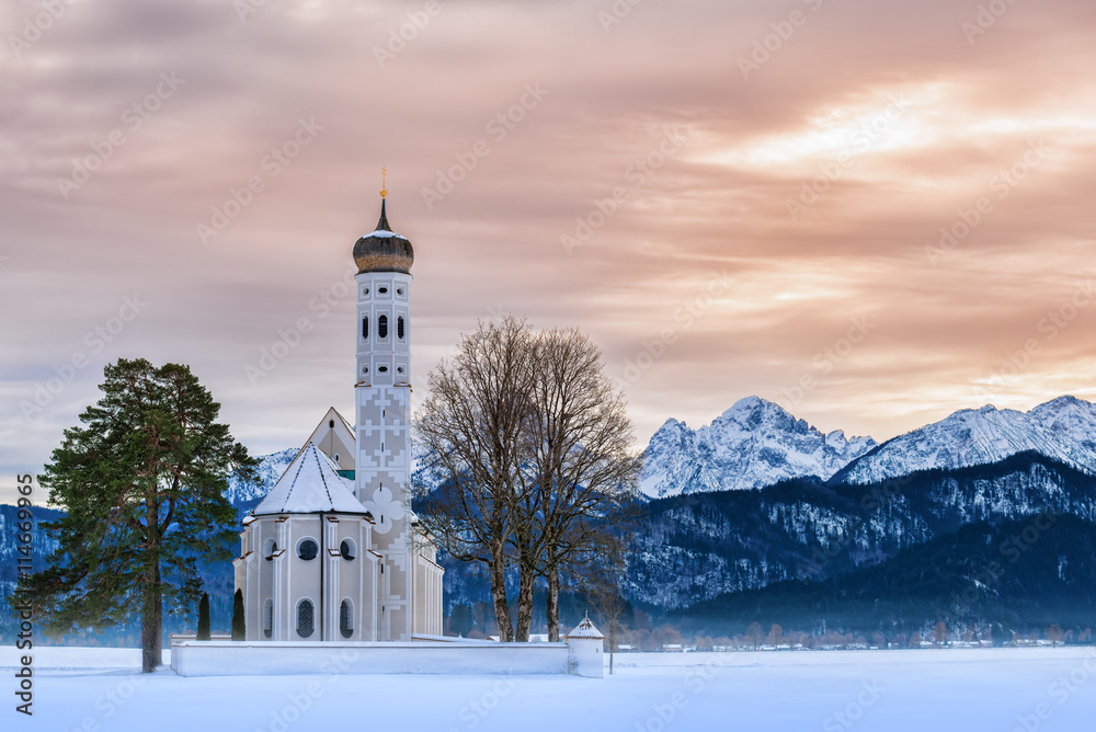 St. Coloman church at sunset on a winter day with snow and frost