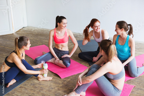 Yoga, fitness, exercise. A group of girls after training sitting on the mat.